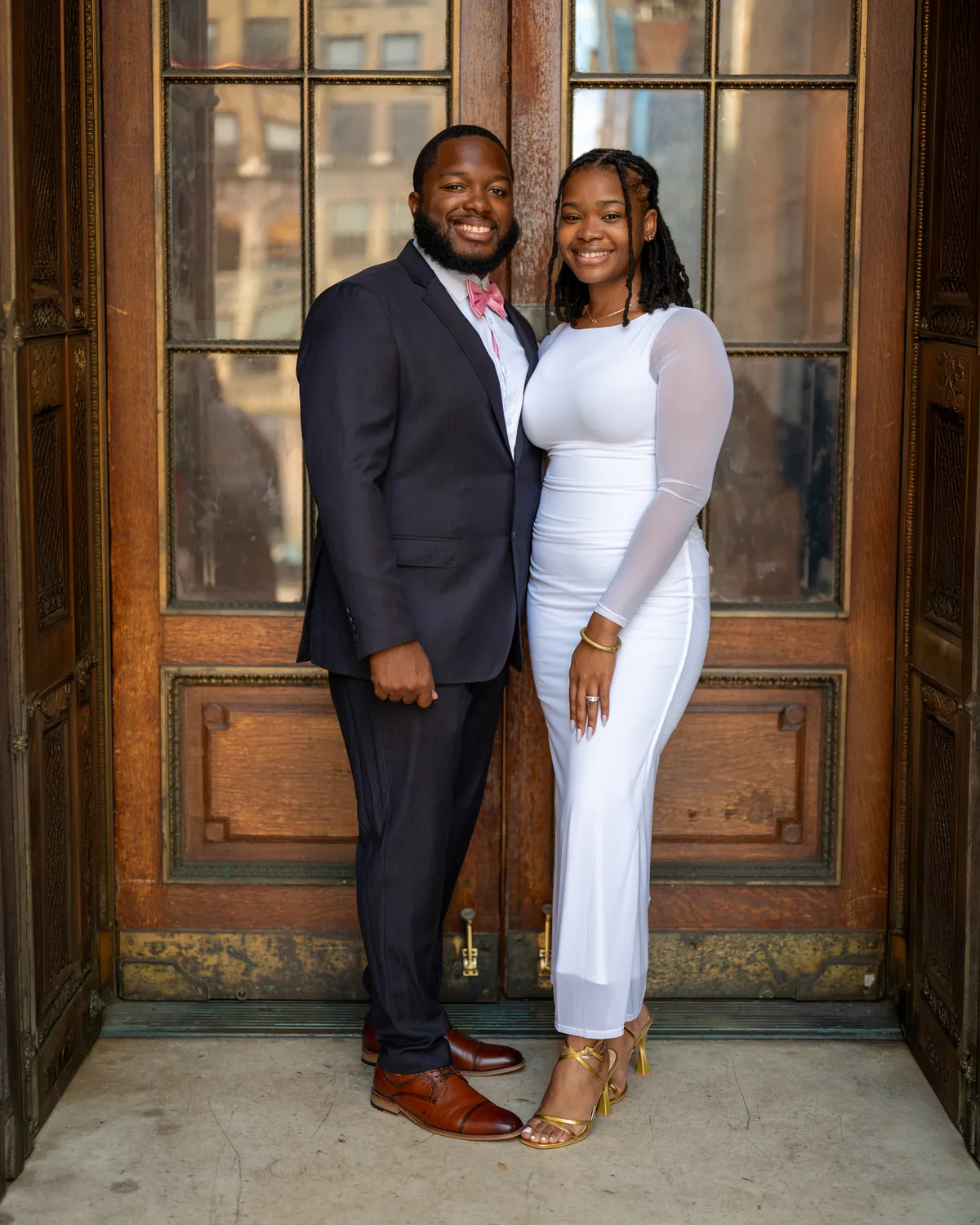 Couple smiling together in a carved wooden doorway