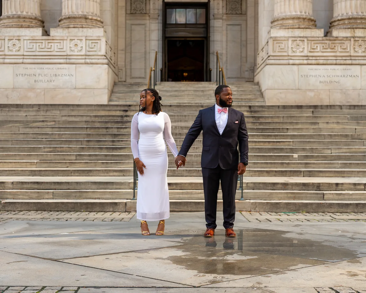 Couple holding hands at the foot of wide stone steps