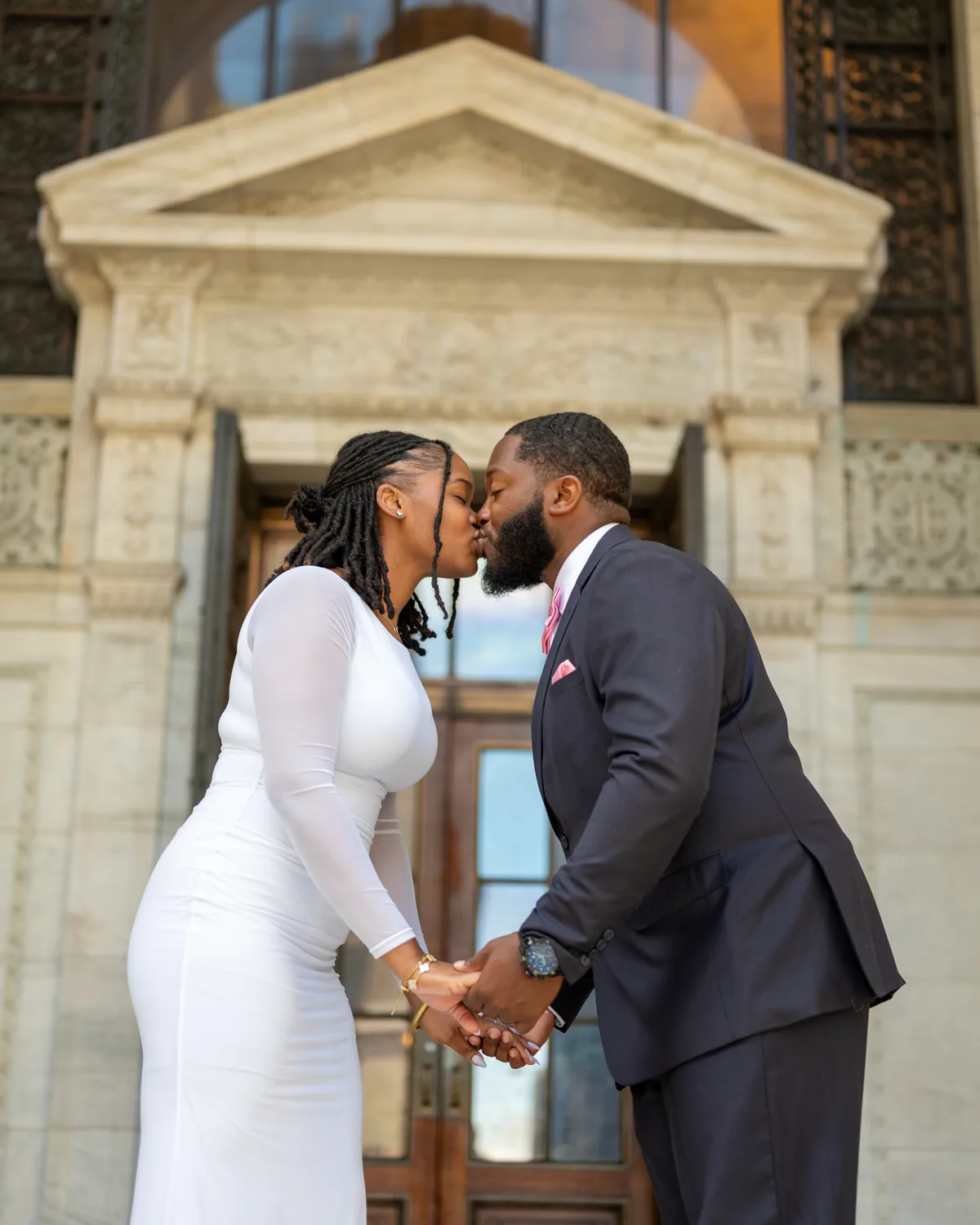 Couple sharing a kiss in front of a stone building