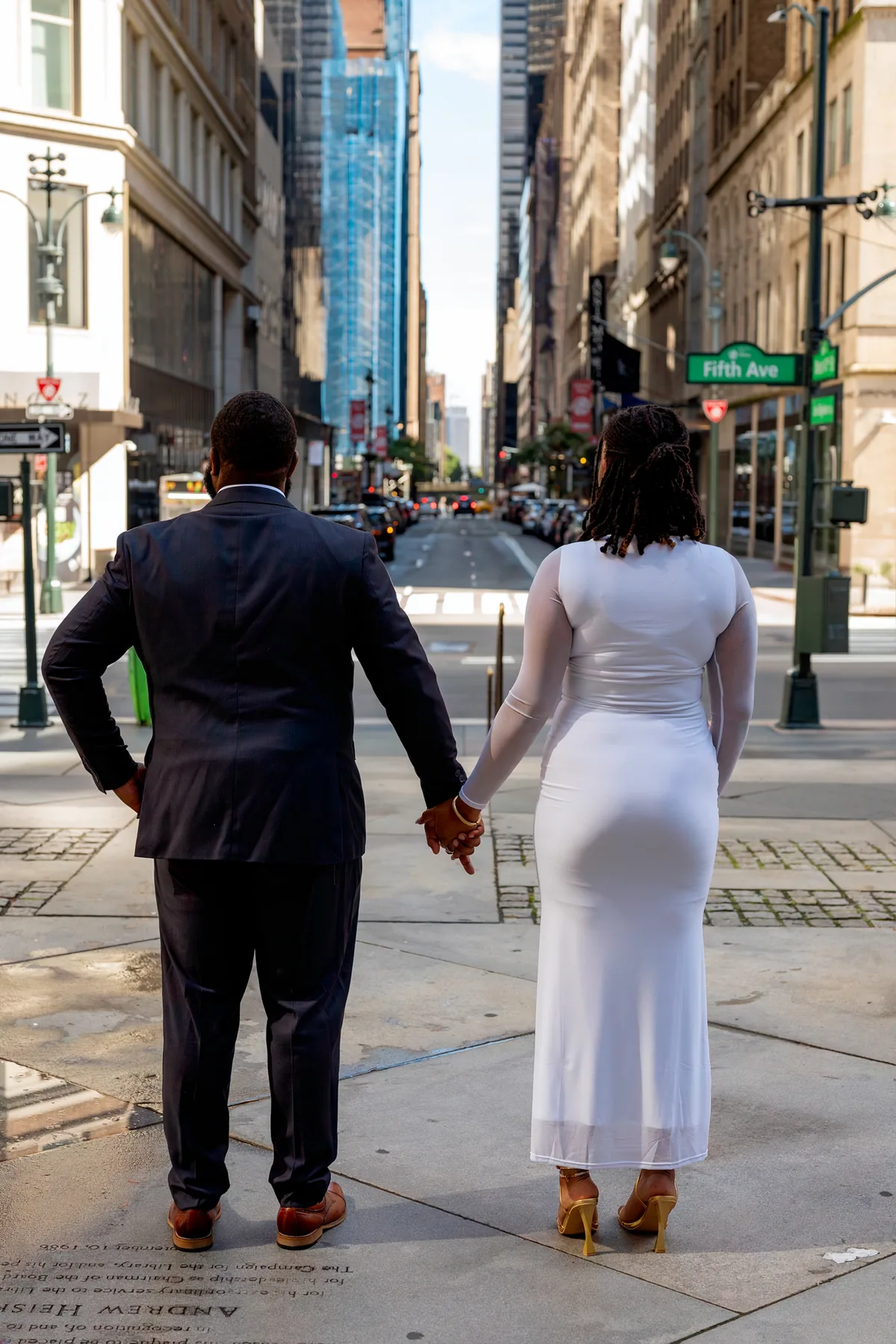 Couple walking hand in hand along a city sidewalk