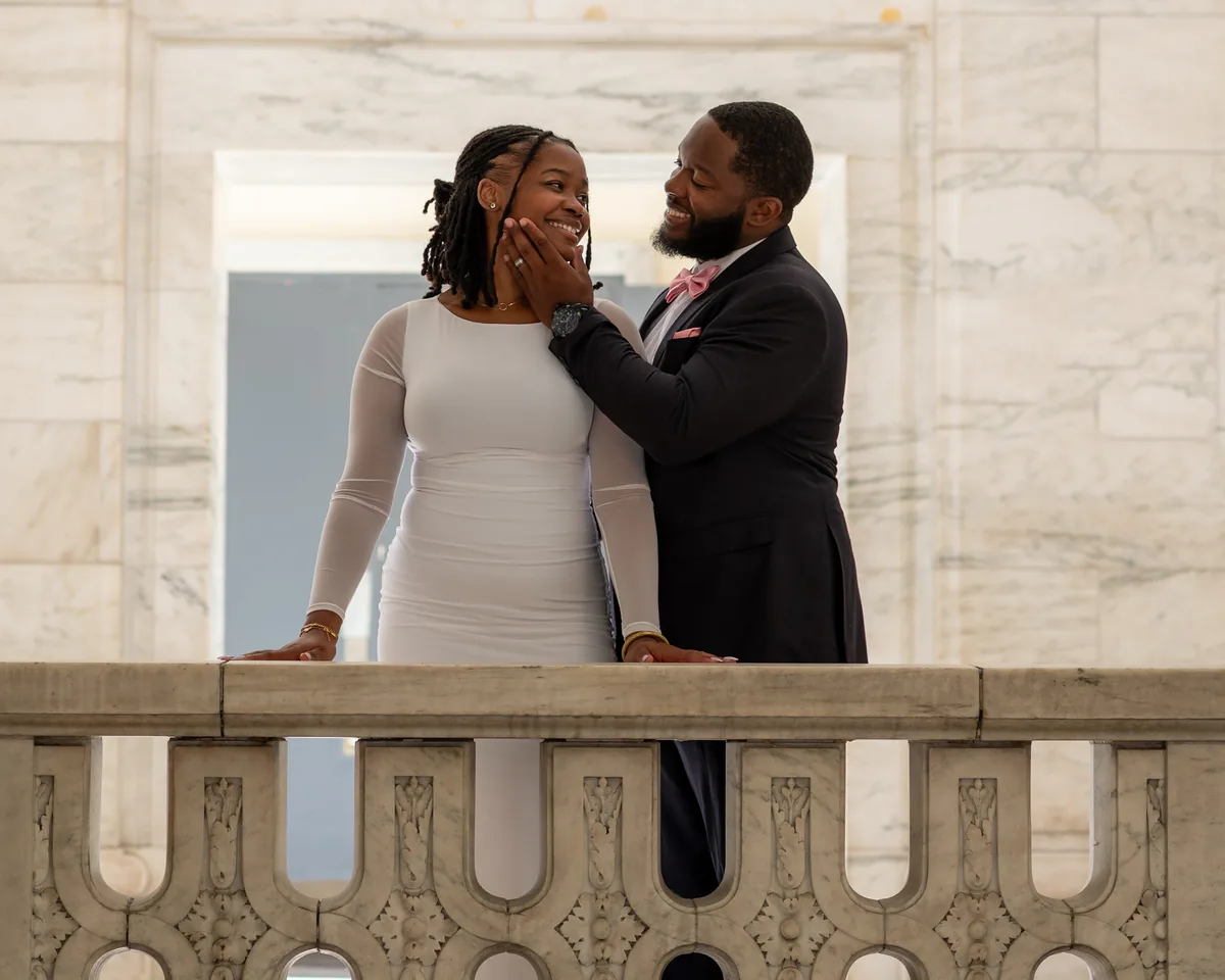 Couple laughing together behind a stone balustrade