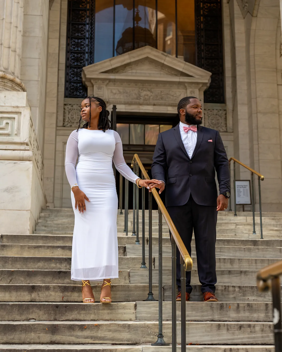 Couple holding hands as they walk down stone steps