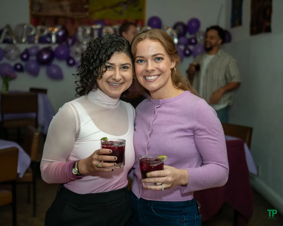 Two smiling guests holding drinks at The Magnet Collective’s first-birthday celebration